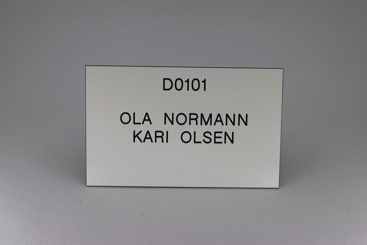 Postkasseskilt Sandbergkassen, 1 linje alltid øverst, hvit plate med svart tekst